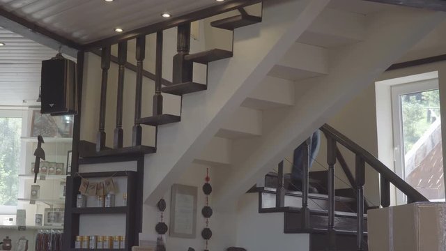 Young Man Wearing Jeans Walking Down Stairs At Home