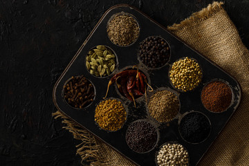 Obraz na płótnie Canvas Indian Spices / Masala Box on a Black Background. With jute.