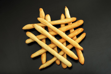 Italian bread, crispy grissini on a black background. Close-up.