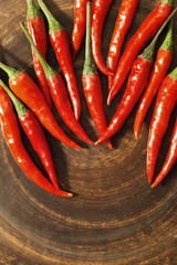Natural food background with red chili peppers close up with free space for text. Flat lay on clay surface.