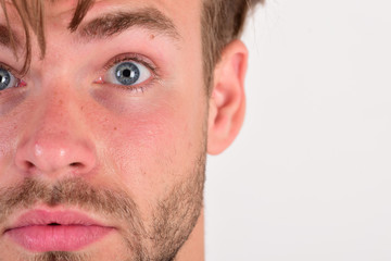 Obraz premium Macho with blue eyes wide open, closeup. Guy with bristle