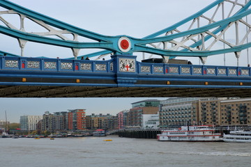 Fragment mostu Tower Bridge w Londynie, Wielka Brytania, w tle zabudowa nabrzeża, Tamiza i statki na niej
