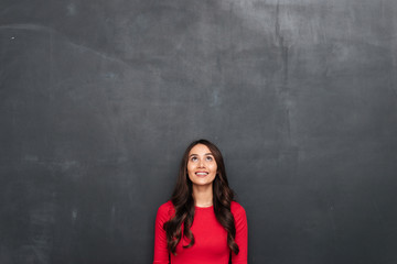 Picture of Happy brunette woman in red blouse looking up