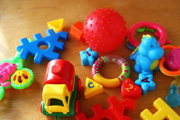 Children's toys and accessories on a wooden background. Top view