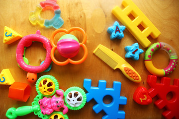 Children's toys and accessories on a wooden background. Top view