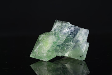 Green natural crystal mineral on a black background