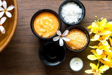 Thai Spa Treatments aroma therapy  salt and sugar scrub and rock massage with yellow orchid flower on wooden.  Healthy Concept.