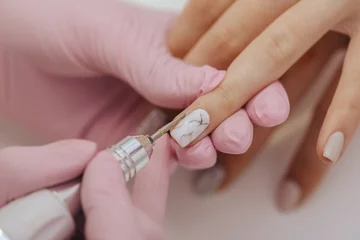 Foto auf Acrylglas Maniküre Manicurist with a milling cutter for manicure