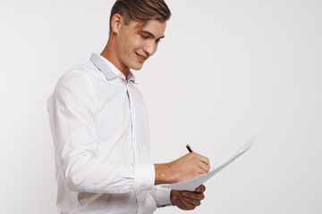 a young man in a white shirt happily signs a paper