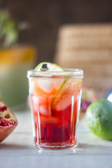 Fresh pomegranate drink - lemonade or cocktail with lime and ice