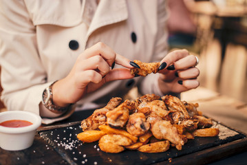 Close up of woman eating chicken wings.