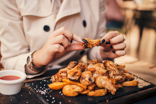 Close Up Of Woman Eating Chicken Wings.