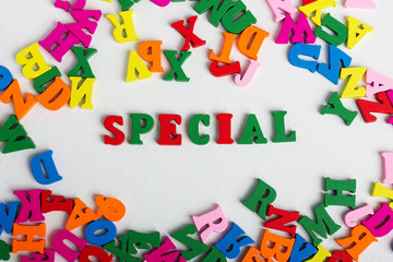 The word special from the colorful wooden letters on a white wooden background