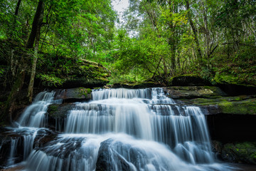 Waterfall with green moss in the tropical rainforest landscape