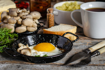 fried eggs in a frying pan and serving on a wooden table
