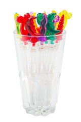 Colorful plastic swizzle sticks in glass on white background with Clipping Path.
