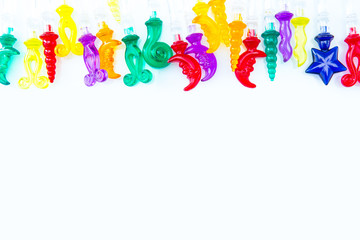 Colorful plastic swizzle sticks on white background with copy space