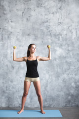Young woman holding dumbbells.