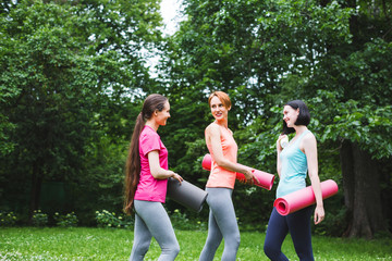 Fitness female group in park on a sunny day. Workout outdoors.