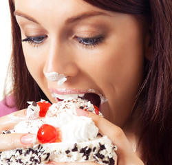 Cheerful woman eating pie, over white