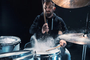 Drummer rehearsing on drums before rock concert. Man recording music on drum set in studio