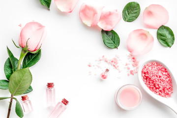Products for skincare based on rose oil. Cream, lotion, spa salt on white background top view copyspace