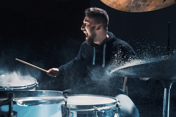 Drummer rehearsing on drums before rock concert. Man recording music on drum set in studio