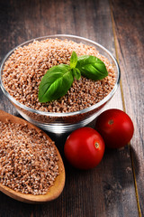 Bowl of uncooked spelt on wooden table