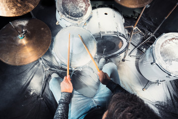 Drummer rehearsing on drums before rock concert. Man recording music on drum set in studio
