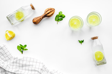 Prepare refreshing beverage lemonade. Lemons, juicer, bottle on white background top view copyspace