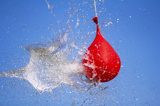 Explosion of balloon full of water on sky background