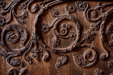 Beautiful texture of wooden wrought and decorated door in european style