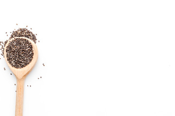 Superfood chia seeds in a wooden spoon on white background top view copyspace