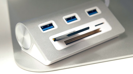 The hand inserts a USB flash drive into the card reader