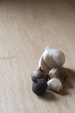 Pile of White and Black Garlic on Wood