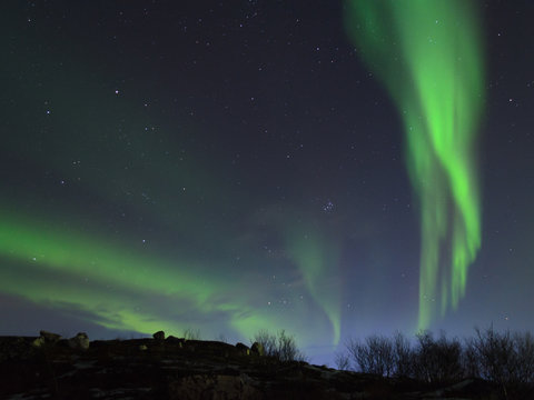 The Aurora in the night sky above the hills.