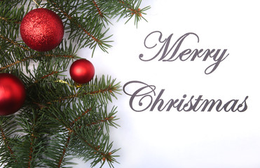 Text merry christmas on paper with fur-tree, branches, colored glass balls , decoration and cones on a wooden background