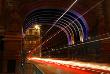 Most Tower Bridge w Londynie, nocą, kolorowo podświetlony, smugi świetlne od poruszających się pojazdów, długi czas naświetlania - obrazy, fototapety, plakaty