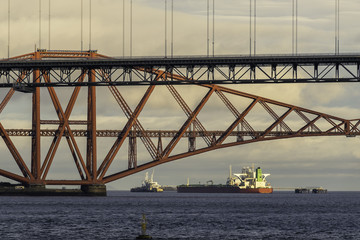 Oil tanker seen under the famous Forth bridge in the Firth of Forth near Edinburgh, Scotland.