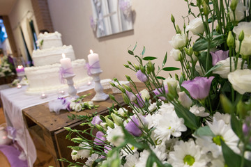 Allestimento decorativo per eventi con fiori, portacandele con candele, lumini e torta