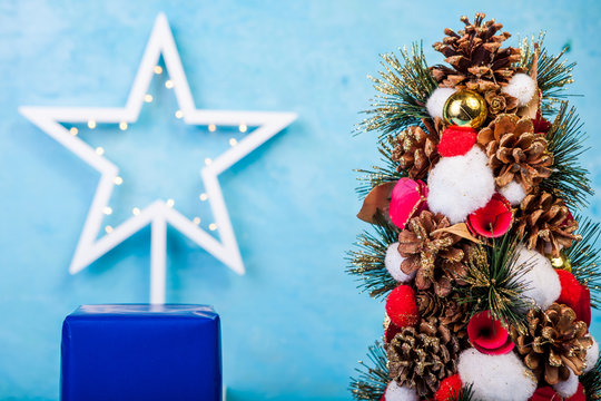 Mini Christmas tree on blue background in studio photo. Seasonal and holiday