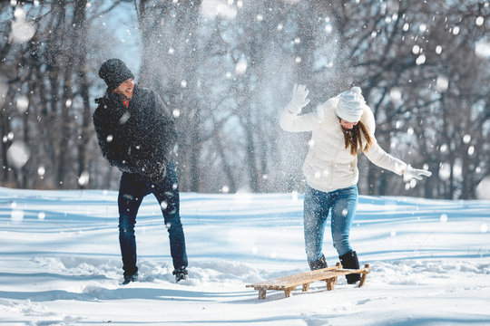 Couple snow fighting and having fun outdoors in winter