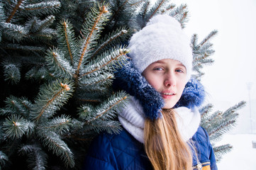 Close-up of girl by the tree in winter with snow