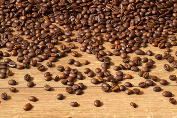 Grains of invigorating coffee on a wooden table