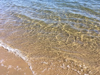 Sandy beach with clear sea water on a sunny day