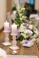 Fototapeta na wymiar Allestimento decorativo per eventi con portacandele con candele, lumini e fiori