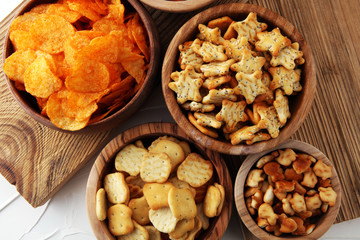 Salty snacks. Pretzels, chips, crackers in wooden bowls.