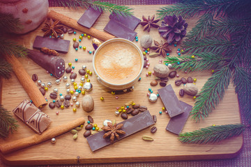 New Year's winter composition with coffee and spices in the kitchen on a wooden dinette and with pine branches. Beauty and inspiration with winter desserts.