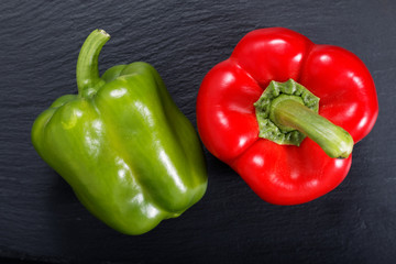 red and green bell pepper on black slate stone plate with copy space