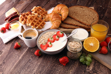 Obraz na płótnie Canvas Breakfast served with coffee, orange juice, croissants, cereals and fruits. Balanced diet
